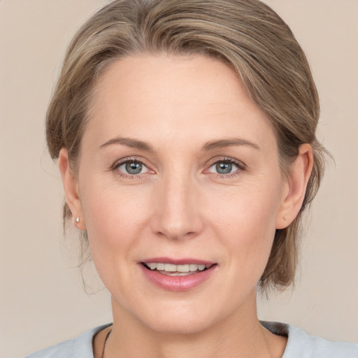 Joyful white adult female with medium  brown hair and grey eyes