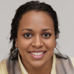 Joyful black young-adult female with long  brown hair and brown eyes