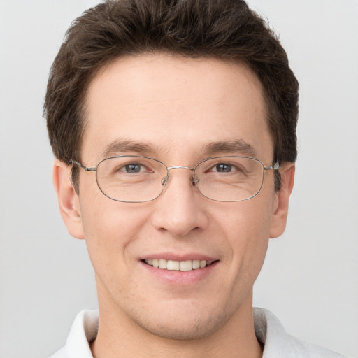 Joyful white adult male with short  brown hair and grey eyes