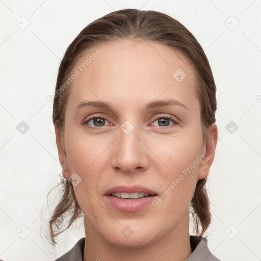 Joyful white young-adult female with medium  brown hair and grey eyes