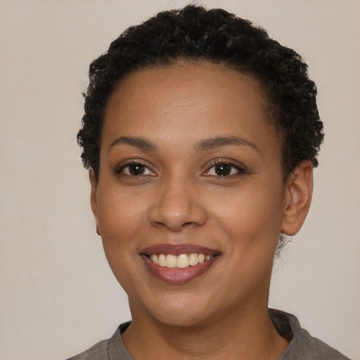 Joyful black young-adult female with short  brown hair and brown eyes