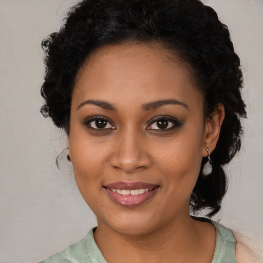 Joyful black young-adult female with long  brown hair and brown eyes