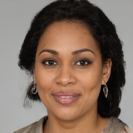 Joyful black young-adult female with long  brown hair and brown eyes