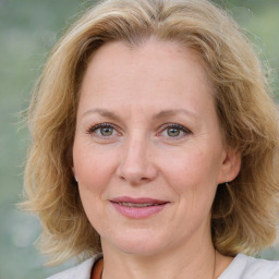 Joyful white adult female with medium  brown hair and blue eyes