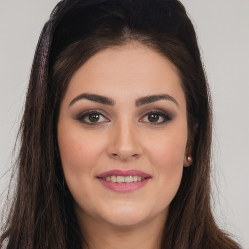 Joyful white young-adult female with long  brown hair and brown eyes