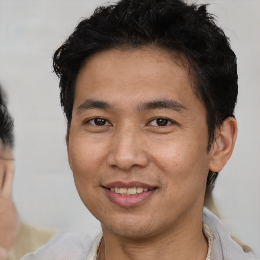 Joyful asian young-adult male with short  brown hair and brown eyes