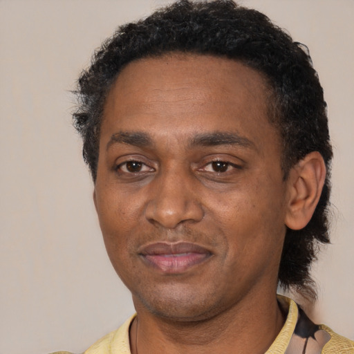 Joyful black adult male with short  black hair and brown eyes
