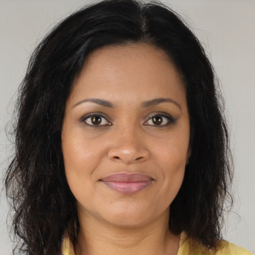 Joyful black young-adult female with long  brown hair and brown eyes