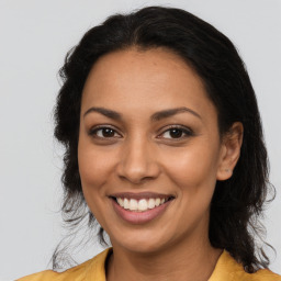 Joyful latino young-adult female with long  brown hair and brown eyes