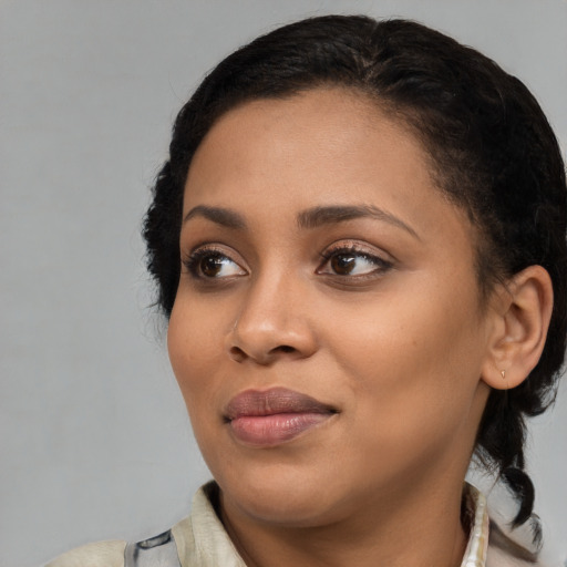 Joyful black young-adult female with medium  black hair and brown eyes