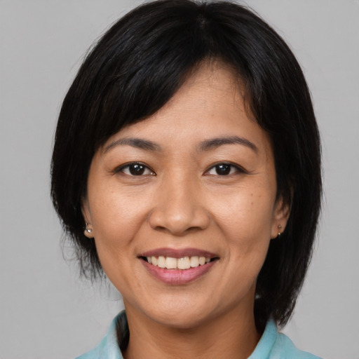 Joyful asian adult female with medium  brown hair and brown eyes