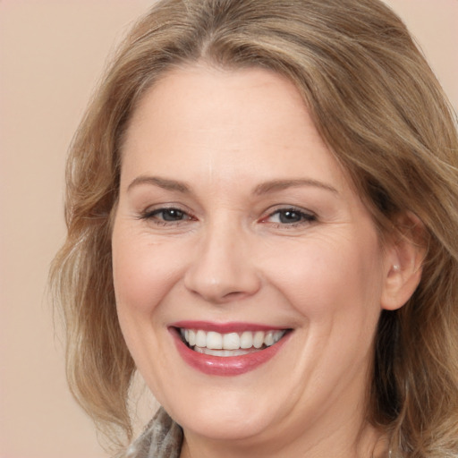 Joyful white adult female with medium  brown hair and brown eyes