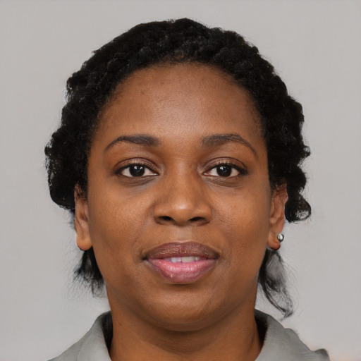 Joyful black adult female with short  black hair and brown eyes