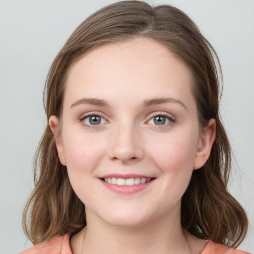 Joyful white young-adult female with medium  brown hair and blue eyes