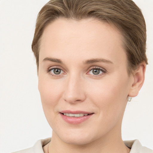 Joyful white young-adult female with short  brown hair and grey eyes