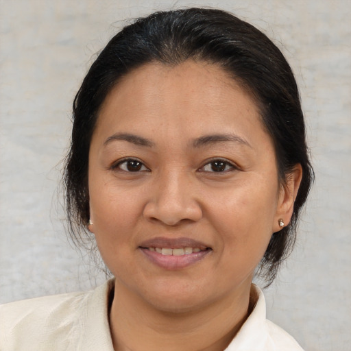 Joyful latino adult female with medium  brown hair and brown eyes
