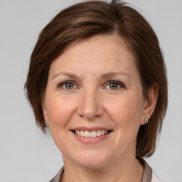 Joyful white adult female with medium  brown hair and grey eyes