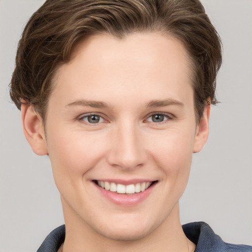 Joyful white young-adult female with short  brown hair and grey eyes