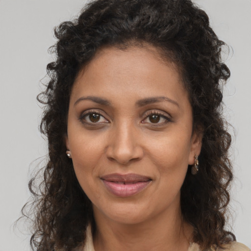 Joyful black young-adult female with long  brown hair and brown eyes