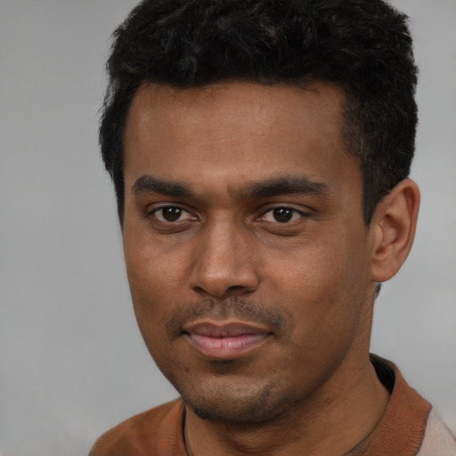 Joyful latino young-adult male with short  black hair and brown eyes
