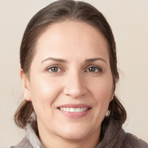 Joyful white young-adult female with long  brown hair and grey eyes