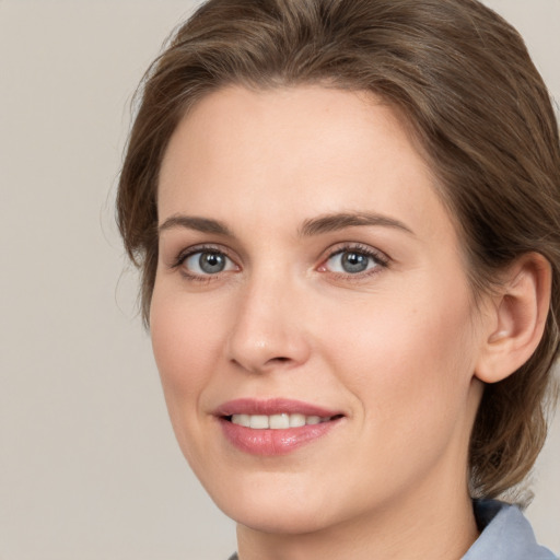 Joyful white young-adult female with medium  brown hair and grey eyes