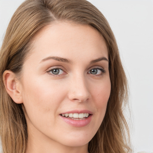 Joyful white young-adult female with long  brown hair and blue eyes