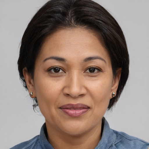 Joyful latino adult female with medium  brown hair and brown eyes
