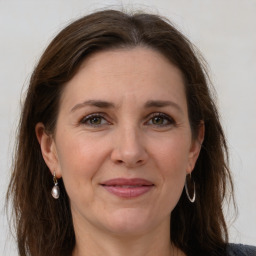 Joyful white adult female with long  brown hair and grey eyes