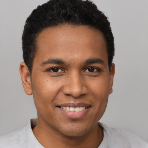 Joyful black young-adult male with short  black hair and brown eyes