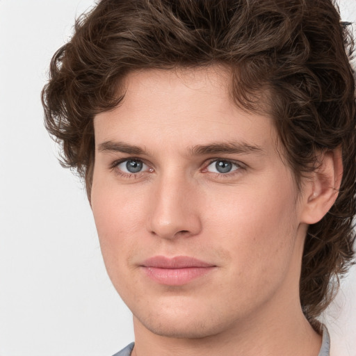 Joyful white young-adult male with medium  brown hair and grey eyes