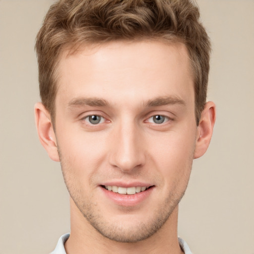 Joyful white young-adult male with short  brown hair and grey eyes