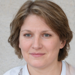 Joyful white adult female with medium  brown hair and blue eyes