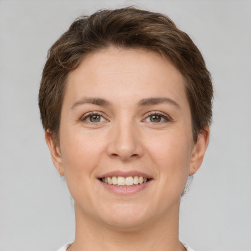 Joyful white young-adult female with short  brown hair and grey eyes