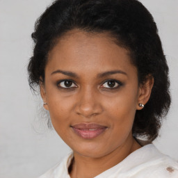 Joyful black adult female with medium  brown hair and brown eyes