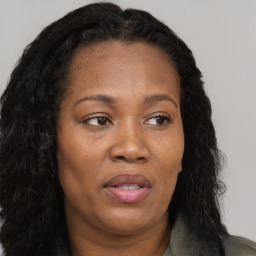 Joyful black adult female with long  brown hair and brown eyes