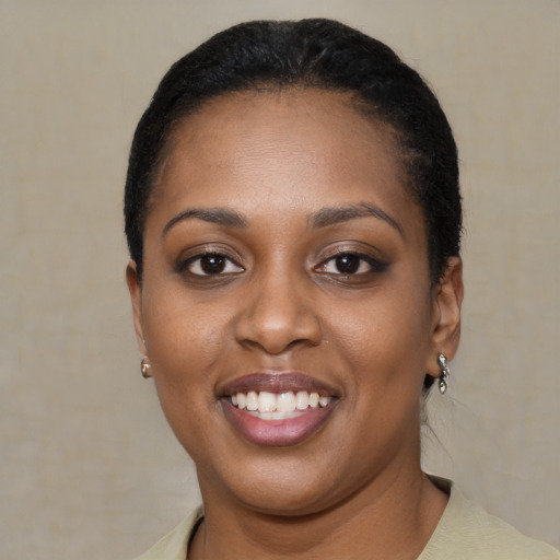 Joyful black young-adult female with short  black hair and brown eyes