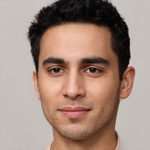 Joyful latino young-adult male with short  black hair and brown eyes