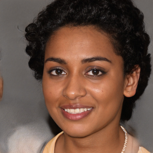Joyful black young-adult female with long  black hair and brown eyes