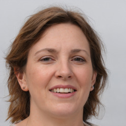 Joyful white adult female with medium  brown hair and grey eyes