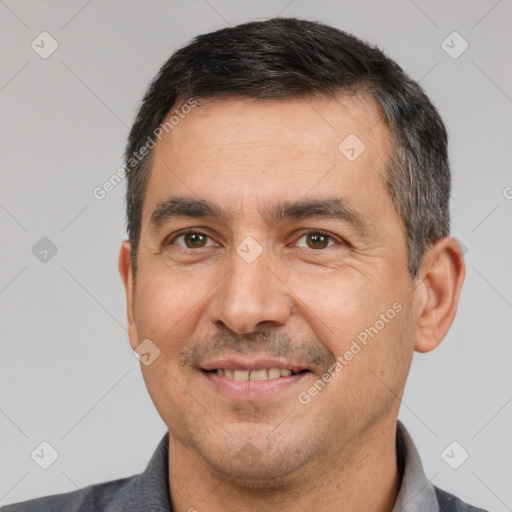 Joyful white adult male with short  black hair and brown eyes