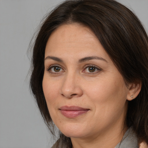 Joyful white adult female with medium  brown hair and brown eyes