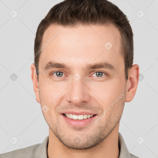 Joyful white young-adult male with short  brown hair and grey eyes