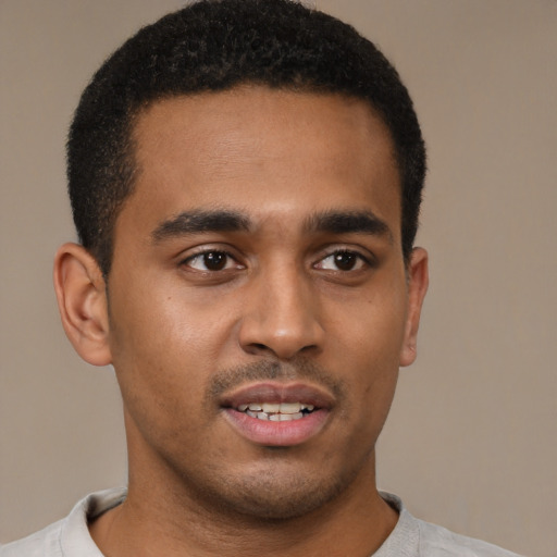 Joyful black young-adult male with short  brown hair and brown eyes