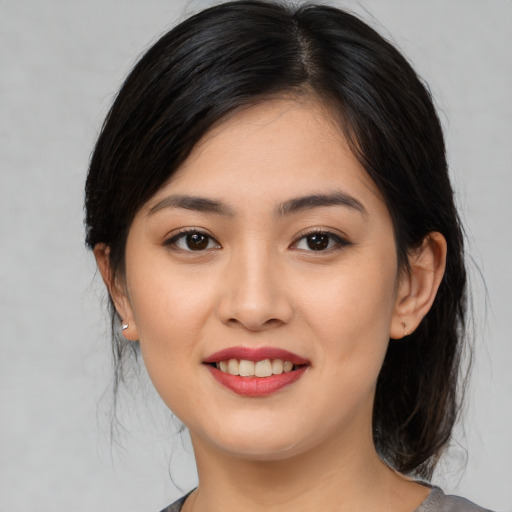 Joyful asian young-adult female with medium  black hair and brown eyes