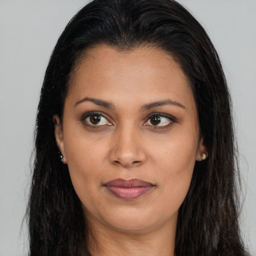 Joyful latino young-adult female with long  brown hair and brown eyes