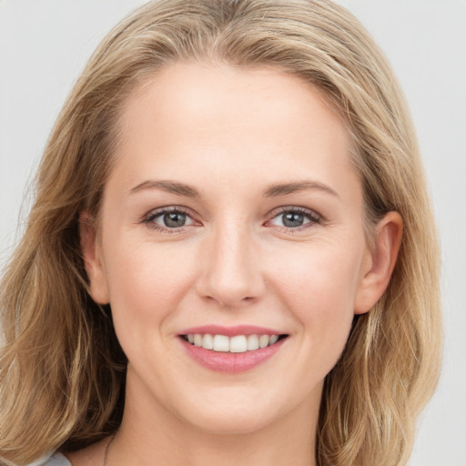 Joyful white young-adult female with long  brown hair and blue eyes