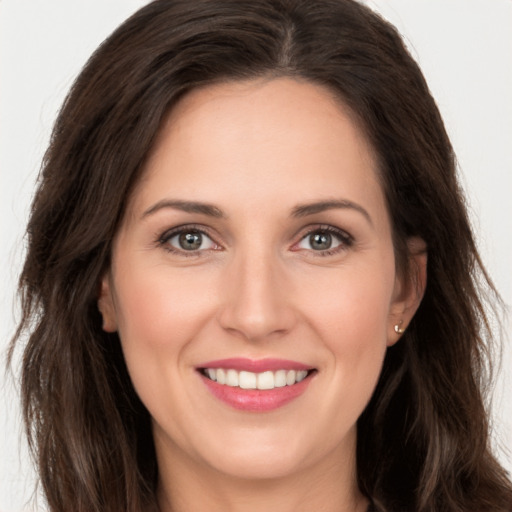 Joyful white young-adult female with long  brown hair and brown eyes