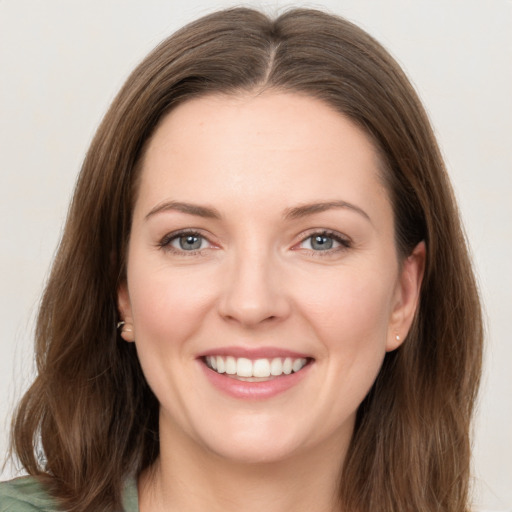 Joyful white young-adult female with long  brown hair and green eyes