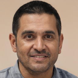 Joyful white adult male with short  black hair and brown eyes
